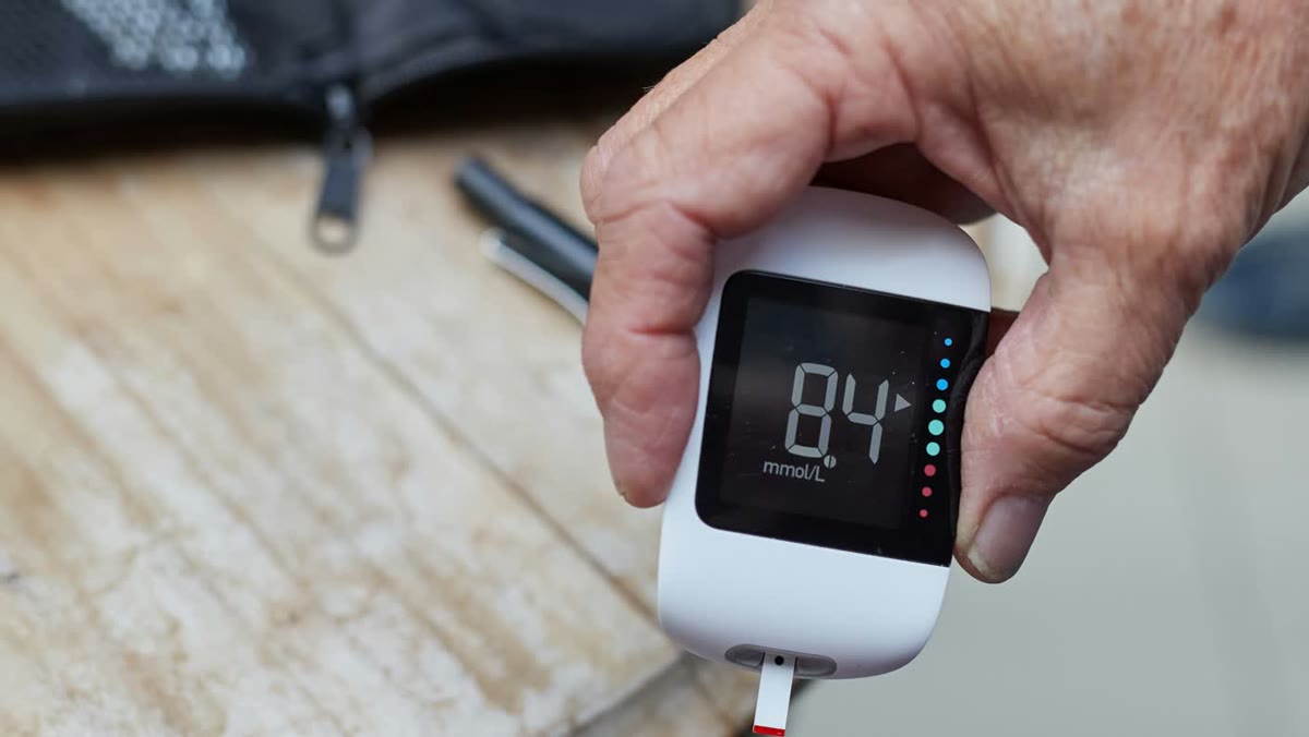 Older adult holding a blood glucose meter